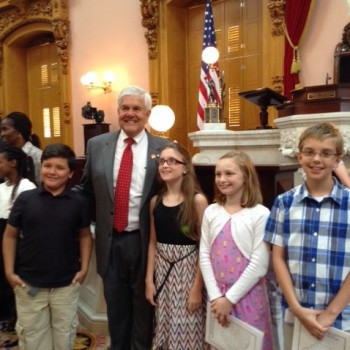 students posing with a man wearing a tie